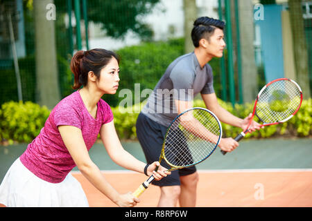 Giovane coppia asiatica di un uomo e di una donna in un doppio misto corrispondono, concentrarsi sulla donna in primo piano Foto Stock