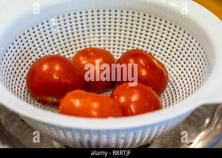 Appena Lavate i pomodori in una bacinella di plastica bianca - Set da cucina Foto Stock