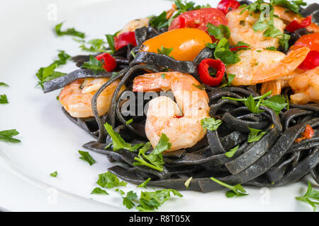 Nero Seppia Fettuccine con gamberi o gamberetti pomodori ciliegia, prezzemolo, peperoncino in vino e salsa di burro. Foto Stock