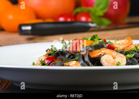 Nero Seppia Fettuccine con gamberi o gamberetti pomodori ciliegia, prezzemolo, peperoncino in vino e salsa di burro. Foto Stock