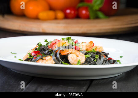 Nero Seppia Fettuccine con gamberi o gamberetti pomodori ciliegia, prezzemolo, peperoncino in vino e salsa di burro. Foto Stock