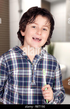 Funny bambino senza alcuni denti spazzolando i suoi denti nella stanza da bagno Foto Stock