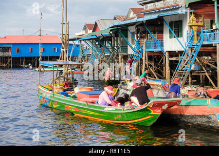 La popolazione locale nelle barche in vendita di merci al di fuori di case su palafitte in villaggio galleggiante nel lago Tonle Sap. Kampong Phluk Siem Reap Cambogia Indocina Asia Foto Stock