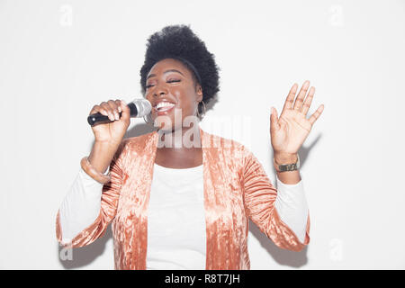 Donna cantare con microfono Foto Stock