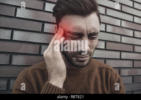 L'uomo sensazione emozioni dolorose, urlando, testimoniando la morte del caro amico, essendo miserabili e devastato, tenendo le palme sulla testa, urla di dolore un Foto Stock