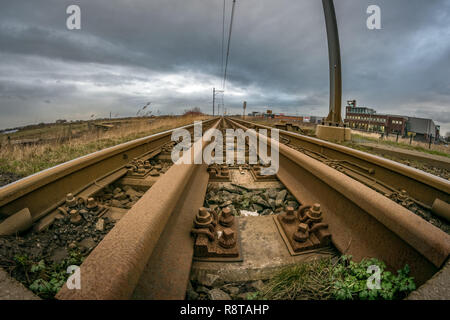 Ampio angolo di visione di un arrugginito railroad che conduce nella distanza. Prospettiva di diminuzione dei binari. Foto Stock