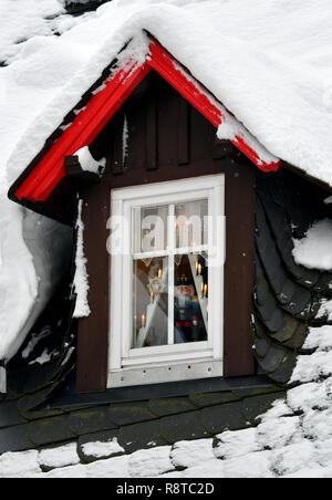 Seiffen, Germania. 15 Dic, 2018. Uno schiaccianoci sta dietro una coperta di neve finestra tetto nel villaggio di giocattolo Seiffen. Durante l'avvento Seiffen è considerato un magnete turistico e attira numerosi turisti da casa e all'estero. Credito: Hendrik Schmidt/dpa-Zentralbild/ZB/dpa/Alamy Live News Foto Stock