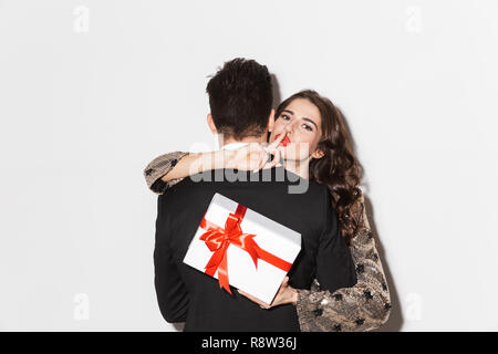 Allegro giovani ben vestiti giovane celebrare la festa di Capodanno isolate su sfondo bianco, tenendo presente la casella Foto Stock