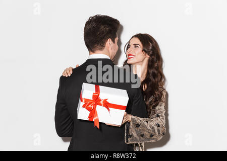 Allegro giovani ben vestiti giovane celebrare la festa di Capodanno isolate su sfondo bianco, tenendo presente la casella Foto Stock