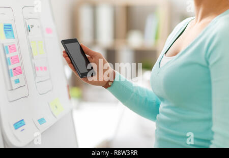 Designer di interfaccia utente o sviluppatore mano azienda smartphone Foto Stock