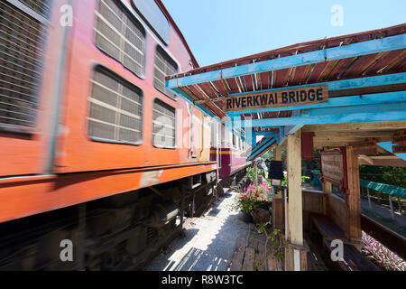 Motion-treno sfocata whizzes passato vecchio gazibo in attesa della ferrovia Siam-Burma oltre il fiume Kwai in Kanchanaburi, Thailandia. Il tristemente famoso Fiume Kwai brid Foto Stock