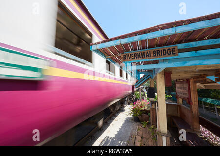 Motion-treno sfocata whizzes passato vecchio gazibo in attesa della ferrovia Siam-Burma oltre il fiume Kwai in Kanchanaburi, Thailandia. Il tristemente famoso Fiume Kwai brid Foto Stock