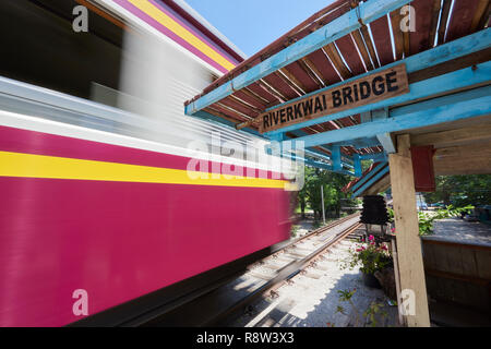 Motion-treno sfocata whizzes passato vecchio gazibo in attesa della ferrovia Siam-Burma oltre il fiume Kwai in Kanchanaburi, Thailandia. Il tristemente famoso Fiume Kwai brid Foto Stock