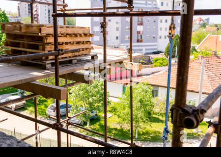 Al di sopra di vista sul impilati in legno stoccati pallet industriali presso un cantiere edile, un edificio residenziale in costruzione. Foto Stock