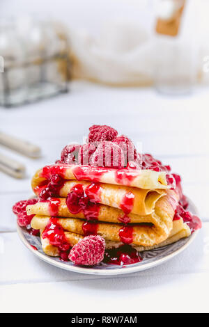 Frittelle impilate con frutti di bosco freschi e zucchero a velo su sfondo chiaro Foto Stock