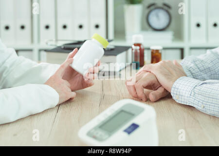 Il paziente e il medico considerando supplemento nutrizionale la terapia in ufficio medico Foto Stock