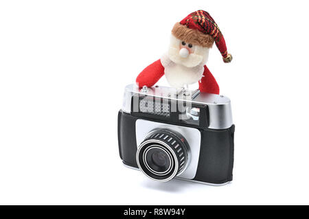 Santa Claus e fotocamera vintage bianco su sfondo isolato per Capodanno e Natale. Babbo Natale fotografo prende le foto e poggia Foto Stock