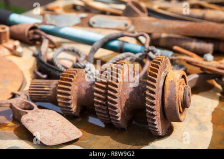 Junkyard con il vecchio ferro arrugginito parti come scatole ingranaggi e ruote dentate Foto Stock