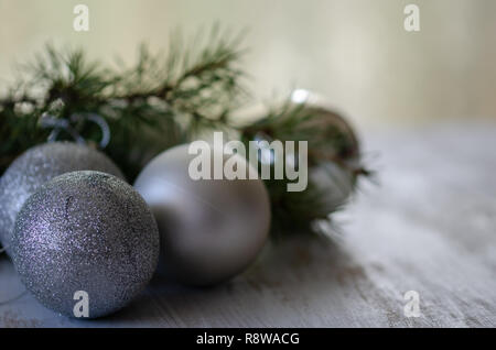 Argento palle di Natale sono anteriore del background di pino. Foto Stock