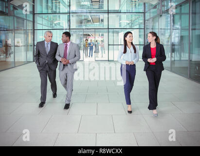 La gente di affari a camminare e parlare al di fuori ufficio moderno edificio Foto Stock