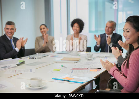 Sorridente la gente di affari battendo le mani nella sala conferenza incontro Foto Stock