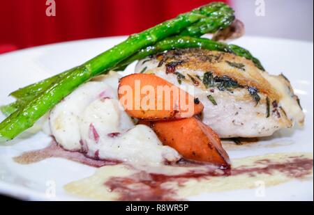 Stati Uniti Army Sgt. Karina Tiree-Williams piatto era, pollo farcito con red muscia di patate, pan disseccata asparagi, oblique carote accompagnati da uno Chardonnay salsa alla panna e salsa al Merlot. Foto Stock