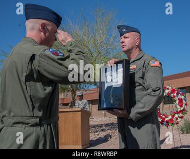 Col. Edwin Slocum, vice wing commander della 161Air Refuelling Wing, accetta il contrassegno di identificazione di Tech. Sgt. Donald J. aratro donata all'ala durante il trentacinquesimo rame annuale 5 Memorial al Goldwater Air National Guard Base, Mar. 13. Aratro era il boom operatore e membro dell'equipaggio a bordo di rame 5, Boeing KC-135A Stratotanker antenna a getto di rifornimento dal 161che è stato coinvolto in una collisione in volo con un aereo civile, uccidendo la persona quattro equipaggi sul Mar 13, 1982. Foto Stock