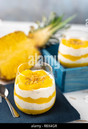 Colpo verticale di mango e ananas smoothie con yogurt in due bicchieri Foto Stock