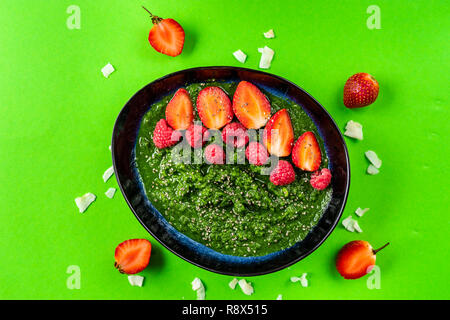 Vista superiore della piastra con spinaci e Frullato di ananas decorato con fragola. Spazio di copia Foto Stock