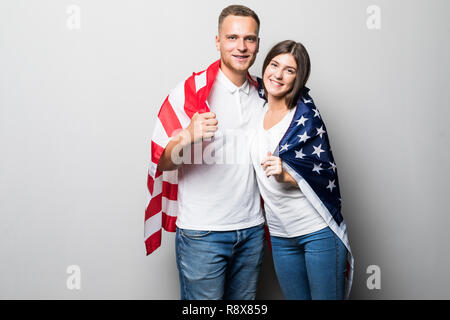 Ritratto di coppia giovane avvolto nella Bandiera americana, isolati su sfondo bianco. Foto Stock