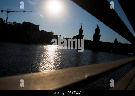 Una silhouette della Oberbaumbruecke visto attraverso le ringhiere di Berlino, Germania. Foto Stock