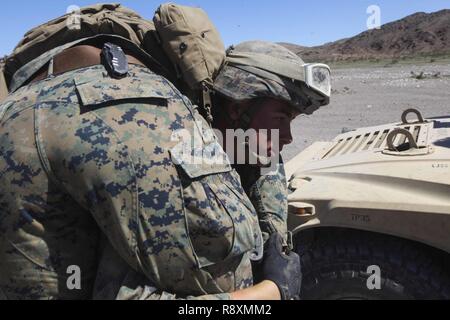 Stati Uniti Marine Corps Lance Cpl. Troy Zahn, un ingegnere di combattimento con supporto per il trasporto di distacco, combattere il battaglione della logistica 15 attaccato al XV Marine Expeditionary Unit, pompiere porta una simulazione di incidente per la sicurezza durante la realistica formazione urbana (RUT) Marine Air Ground Task Force Training Center ventinove Palms, California, 13 marzo 2017. Il ferito Marine ha agito come se colpito da una improvvisata dispositivo esplosivo. MEUs funzionano in modo continuo attraverso il globo e fornire il presidente e la unified comandanti combattente con un forward-distribuito, flessibile e reattiva sea-base Air-Gro Marine Foto Stock