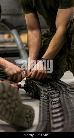 Stati Uniti Marine Corps Lance Cpl. Holland Stewart e Lance Cpl. Stetson Johnston, entrambi aviation ordnance tecnici con Marine Attacco leggero elicottero Squadron (HMLA) 269, esegue le operazioni di manutenzione su un arma sistema di alimentazione durante un tempo freddo esercizio a Wheeler-Sack Army Air Field, N.Y., 9 marzo 2017. HMLA-269 ha partecipato nel freddo di formazione per sviluppare le competenze e per meglio preparare l'unità per le condizioni meteorologiche estreme. Foto Stock