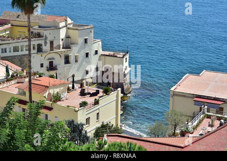 Terrazza mediterranea case costruire sulle ripide pareti rocciose lungo la costa scoscesa con belle vedute del mare blu. Foto Stock