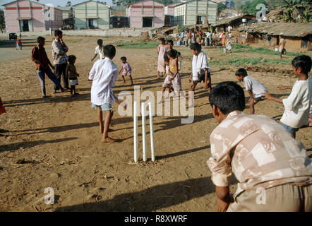 I bambini a giocare a cricket in baraccopoli, Mumbai Bombay, Maharashtra, India Foto Stock