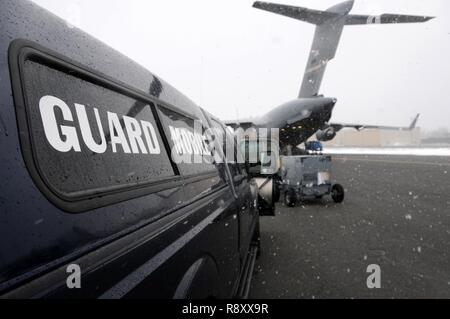 Membri assegnati alla 104th Fighter Wing, Massachusetts Air National Guard, attrezzature di carico su un C-17 Globemaster III, assegnato alla 445th Airlift Wing, Wright Patterson Air Force Base in Ohio. Il C-17 defunti Barnes Air National Guard Base, Marzo 14, 2018 come parte di un teatro Pacchetto di sicurezza in supporto del funzionamento Atlantic risolvere. Una volta che il teatro, il carico sarà inviato a più posizioni a sostegno di esercizi e di formazione con i nostri alleati e partner. Foto Stock