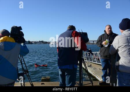 Un guardacoste degli Stati dimostra l'uso di acqua fredda tuta di immersione per le notizie locali media al Coast Guard settore nord del New England, Venerdì, 7 dicembre 2018. La Guardia Costiera ha ospitato l'evento per evidenziare l'importanza commerciale di sicurezza per i pescherecci e le recenti Novembre 14 Il salvataggio di tutti i quattro membri di equipaggio a bordo del peschereccio Aaron & Melissa II, circa 60 miglia al largo della costa di Rockland, Maine. Foto Stock