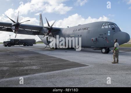 Il personale Sgt. Christopher Canto, 374 Manutenzione aeromobili squadrone battenti capo equipaggio, comunica con il resto del suo team a bordo di una C-130J Super Hercules via radio durante il processo di rifornimento di carburante a funzionamento caduta di Natale 2018 presso Andersen Air Force Base, Guam, Dicembre 9, 2018. OCD è un accordo trilaterale missione di formazione progettate per fornire C-130 equipaggi DA PARTE DEGLI STATI UNITI Air Force, JASDF e Royal Australian Air Force una possibilità di airdrop fornisce sulle nazioni unite-intervistate le zone di trascinamento in tutto il Pacifico. Foto Stock