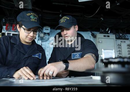 Oceano atlantico (Mar. 5, 2017) Quartermaster Marinaio Giuseppe Speranzella dà scheda di manovra la formazione per Specialista operazioni marinaio apprendista Stephanie Medina sul ponte a bordo dell'assalto anfibio nave USS Bataan (LHD 5). Il Bataan è distribuito come supporto di le operazioni di sicurezza marittima e di teatro di sicurezza gli sforzi di cooperazione in Europa e il Medio Oriente. Foto Stock
