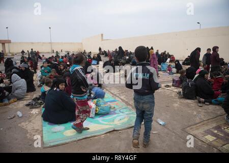 Le donne e i bambini in attesa in una stazione di lavorazione per gli sfollati interni prima di essere trasportati in campi per rifugiati nei pressi di Mosul, Iraq, Marzo 03, 2017. Foto Stock