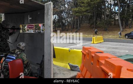 Airman 1. Classe Benjamin Hauber, 8 delle forze di sicurezza Squadron membro del team, tira la sicurezza in un bunker come forze opposte in anticipo, mentre Airman 1. Classe Jeremy Parnell, 8 delle forze di sicurezza Squadron defender, ricarica la sua arma tenendo il coperchio in un bunker durante l'esercizio Beverly Pack 17-2, un non-avviso esercitazione a Kunsan Air Base, Repubblica di Corea, Marzo 7, 2017. Siamo in treno per impiegare airpower a dissuadere aggressione, preservare l'armistizio e difendere la Repubblica di Corea. Foto Stock