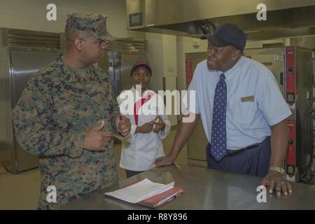 Stati Uniti Marine Corps Master Gunnery Sgt. Derreck Steele, sinistra, il personale non incaricato ufficiale responsabile, cibo servizio scolastico, Fort Lee, si consulta con il personale per valutare il modo in cui il programma è eseguito in corrispondenza della zona 31 mess hall su Camp Pendleton, California, 7 marzo 2017. Il William Pendleton Thomas Hill concorso si è svolta a giudicare la migliore sala mensa in Marine Corps. Foto Stock