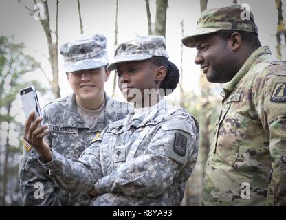 Stati Uniti La riserva di esercito di Spc. Irelin Odonnell (sinistra), SPC. Breatta gru (centro), e PFC. Carlton Ashley, tutti gli specialisti di alimentazione assegnato alla sede centrale e sede società, 335a comando di segnalazione (teatro), prendetevi un momento per condividere un ridere a un video sulla gru il telefono durante una pausa di allenamento piloti a Sykes Park in East Point, Georgia, Marzo 10. L'evento di formazione, ha insegnato quasi 10 esercito di soldati di riserva le competenze necessarie per operare sulla sicurezza un Humvee e una luce di medie veicolo tattico (LMTV), ed è stata la prima formazione del suo genere ad essere ospitato da 335sc (T). Cpl. Eric Adcock, il trainer Foto Stock