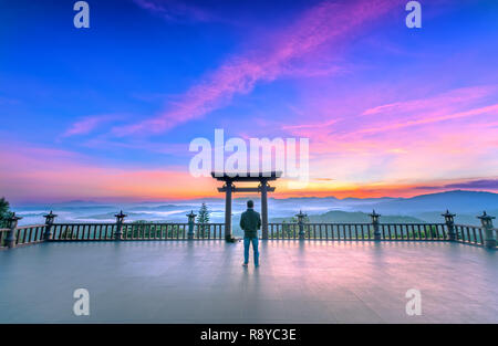 L'uomo meditando davanti il tempio come un modo per rilassarsi anima nel reame spirituale di pace di deposizione in cui Buddha porta in mattinata Foto Stock