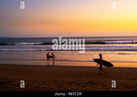 Surfisti sulla spiaggia al tramonto panoramico, Bali, Indonesia Foto Stock