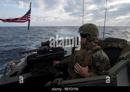 OKINAWA, in Giappone (12 marzo 2017) lancia Cpl. Giacobbe Adamson assegnato al battaglione di team di atterraggio, 2° Battaglione, 5 Marines, sorge guarda all'interno di una elevata mobilità multiuso di veicolo a ruote a bordo landing craft utility (LCU) 1666. LCU 1666, assegnato alla spiaggia navale unità 7, sbarcati dal trasporto anfibio dock nave USS Green Bay (LPD 20) per condurre una lotta contro la razzia di gomma craft beach raid con i Marines. Green Bay, parte dell'Bonhomme Richard Expeditionary Strike gruppo, con avviato 31 Marine Expeditionary Unit, è su una pattuglia di routine, operando in Indo-Asia-regione del Pacifico per en Foto Stock