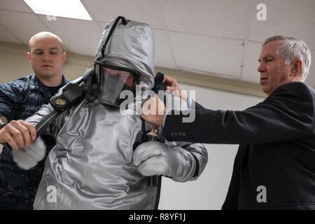 GROTON, Connecticut. (Mar. 8, 2017) Cleveland Heath, destra, technical program manager con Marina di abbigliamento e tessili impianto di ricerca (NCTRF) e macchinista compagno del nucleare classe 2a Nicholas Lewis, dal Los Angeles class-attacco sommergibile USS Toledo (SSN 769), aiuto macchinista compagno del nucleare classe 2a Cameron Sebastian don un prototipo di sommergibile tuta vapore ensemble durante un orientamento di classe tenutosi a Naval base sottomarina di New London. La Marina Mare Comando Sistemi (NAVSEA) tramite l'Ufficio del Naval Research (ONR) TechSolutions Ufficio ha finanziato NCTRF per sviluppare la prossima generazione di equipaggiamenti protettivi per e Foto Stock