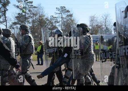 Stati Uniti Air Force delle forze di sicurezza aviatori da 116aria ala di controllo e la 165Airlift Wing, Georgia Air National Guard, insieme con i funzionari di Macon-Bibb dello sceriffo della contea di Office, il salvataggio di un agente opponente da simulare un tumulto durante il vigile protezione 2017, una folla-esercizio di controllo, 15 marzo 2017, Macon, Ga. Il aviatori hanno partecipato alla preparazione alle situazioni di emergenza esercizio vigile protezione grazie alla partnership con Macon-Bibb EMA e altre agenzie per integrare correttamente la folla a tecniche di controllo durante un uragano simulazione per garantire la sicurezza dei cittadini durante eventuali calamità naturali o catas Foto Stock