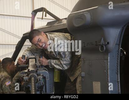 Stati Uniti Air Force Tech. Sgt. Allan Manuel, xviii ingegnere civile Squadron non commissionato ufficiale responsabile del rivestimento protettivo, assume il controllo di un lato-montato M-2 mitragliatrice, 15 marzo 2017, a Kadena Air Base, Giappone. La HH-60G Pave Hawk dispone di due M-2s, uno montato su ciascun lato del velivolo. Foto Stock