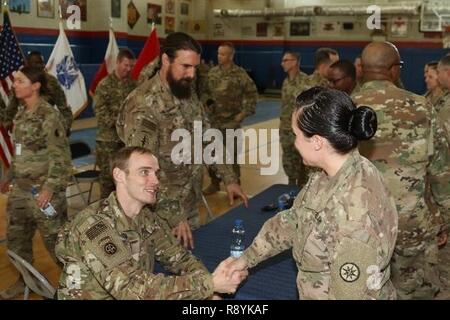 Esercito pensionato Sgt. Willard Hoyum, veicolo a ruote meccaniche, in precedenza con una società, 307th brigata battaglione di supporto, ottantaduesima Airborne Division, scuote la mano di un soldato dispiegata, Marzo 14, 2017, il Camp Arifjan in Kuwait. L'incontro e saluto ha concluso il primo municipio incontro di soldati di funzionamento corretto uscire darà prima di ritornare alla posizione dove hanno ricevuto la loro lotta contro gli infortuni. Foto Stock